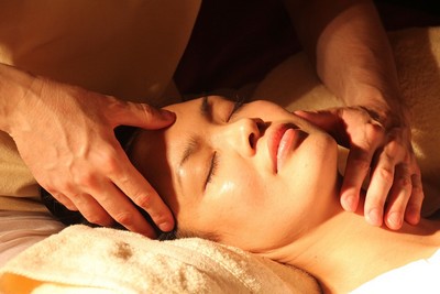 On pratique des pressions en utilisant un outil de Gua Sha le long des canaux spécifiques et des points d'acupuncture sur la peau du visage.